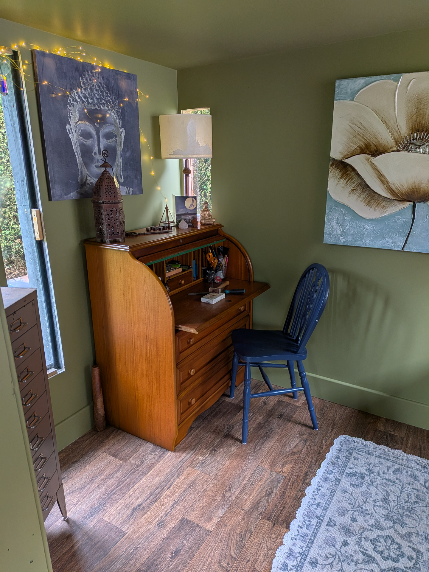 The Calluna Moss studio — a sage-green room with a vintage roll-top writing bureau, sacred art and warm window light